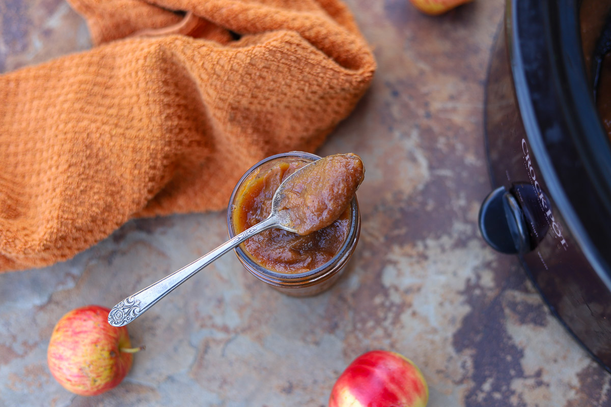 apple butter in a jar with a spoonful on top of the jar