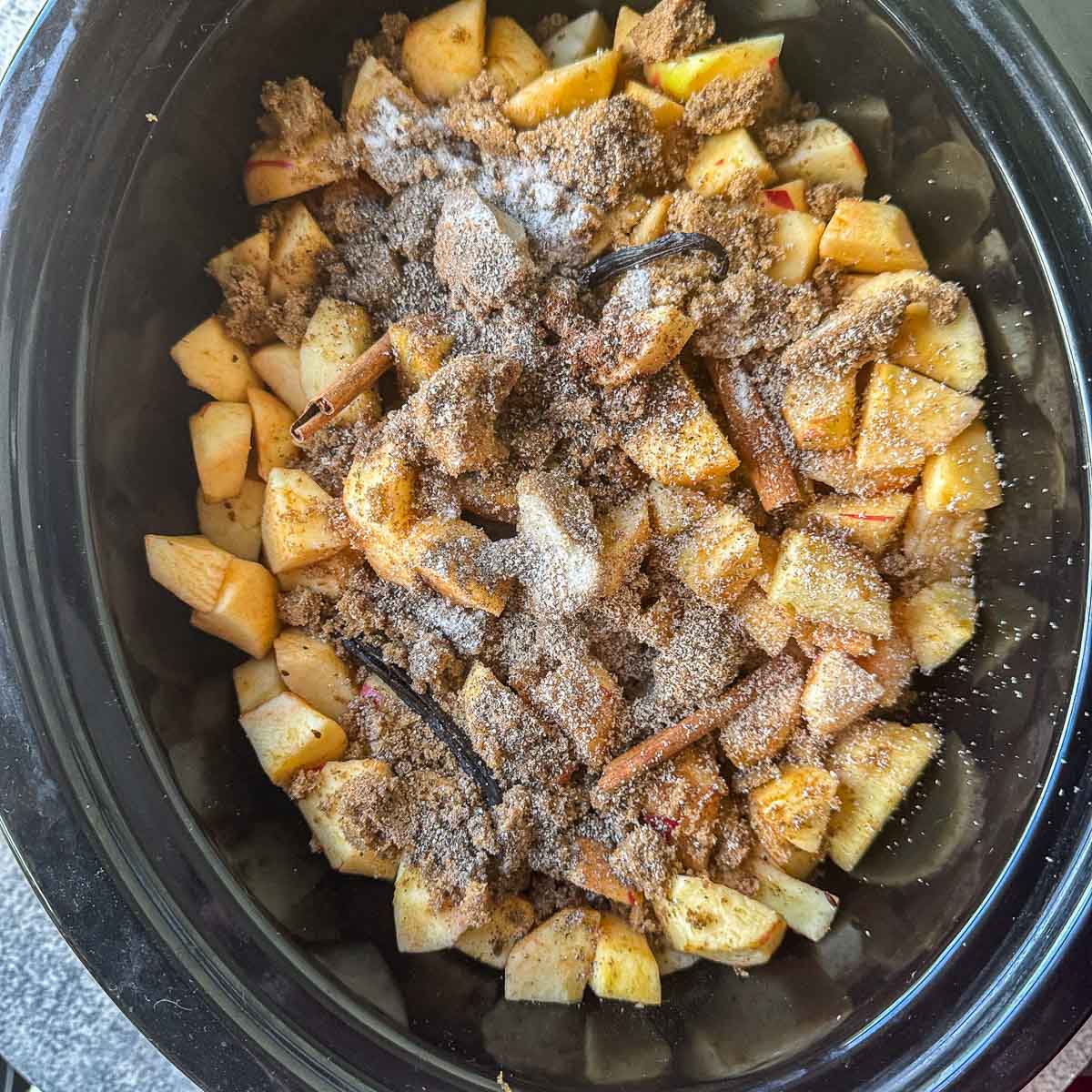 chopped apples and spices in a slow cooker