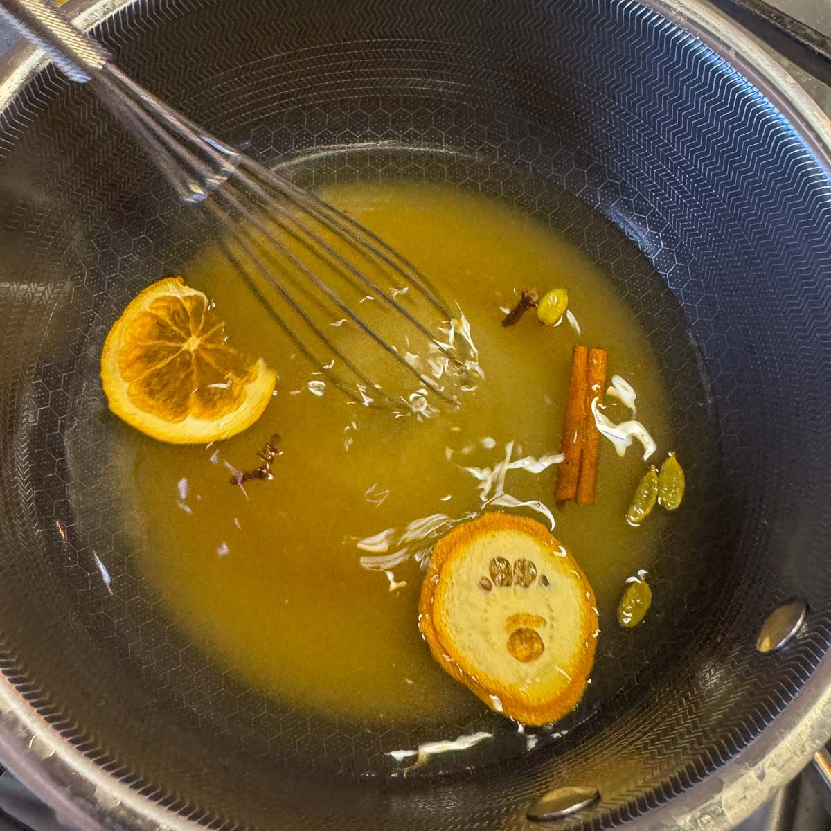 syrup ingredients in a saucepan with a whisk